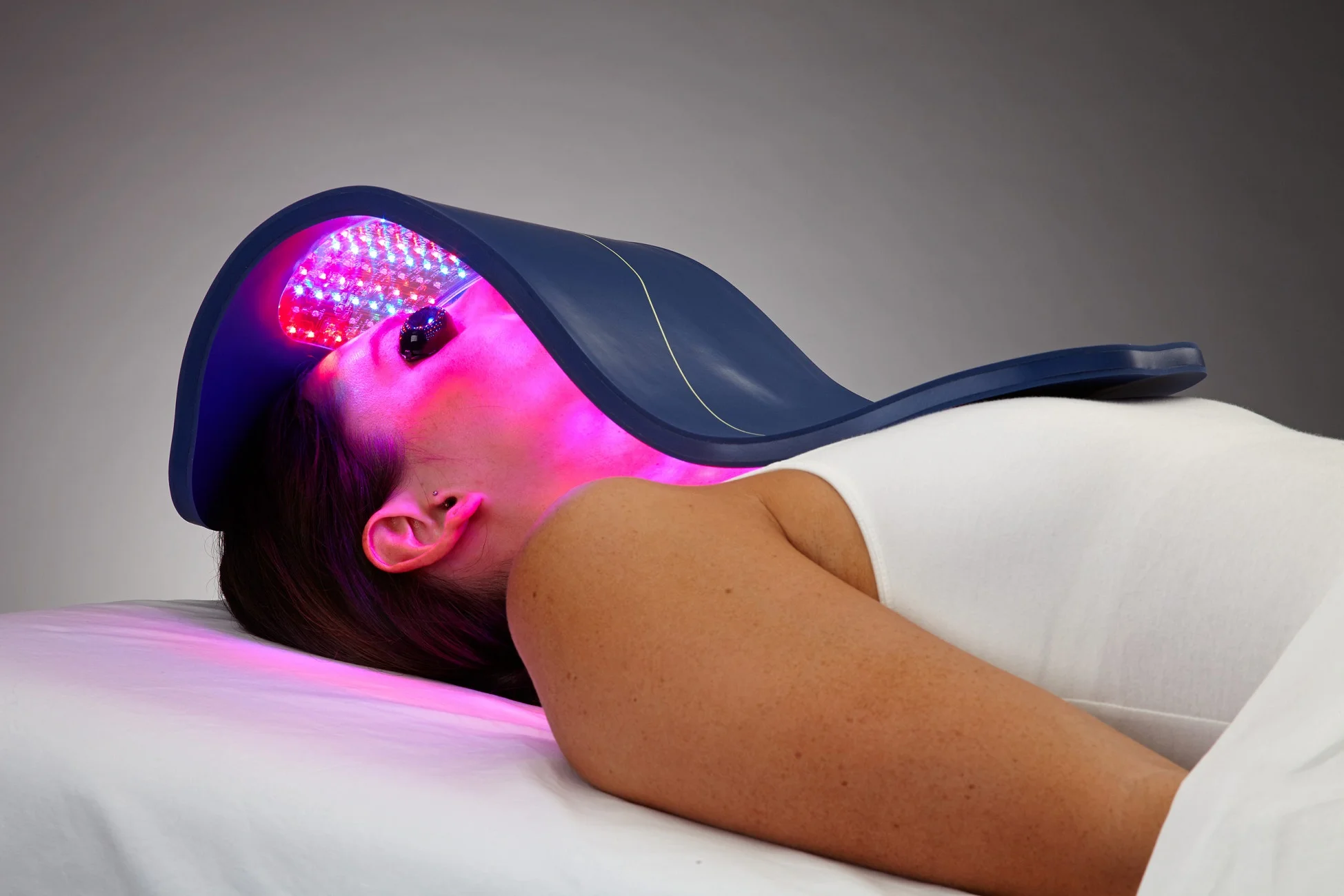A woman undergoing LED therapy with a light-emitting mask for skin rejuvenation.