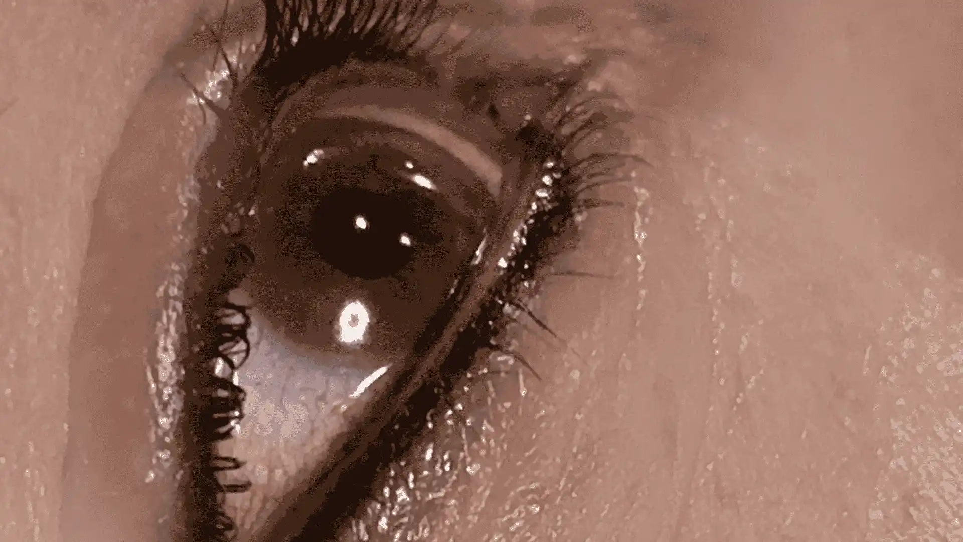 Close-up of an eye showcasing eyeliner treatments, with defined lashes.