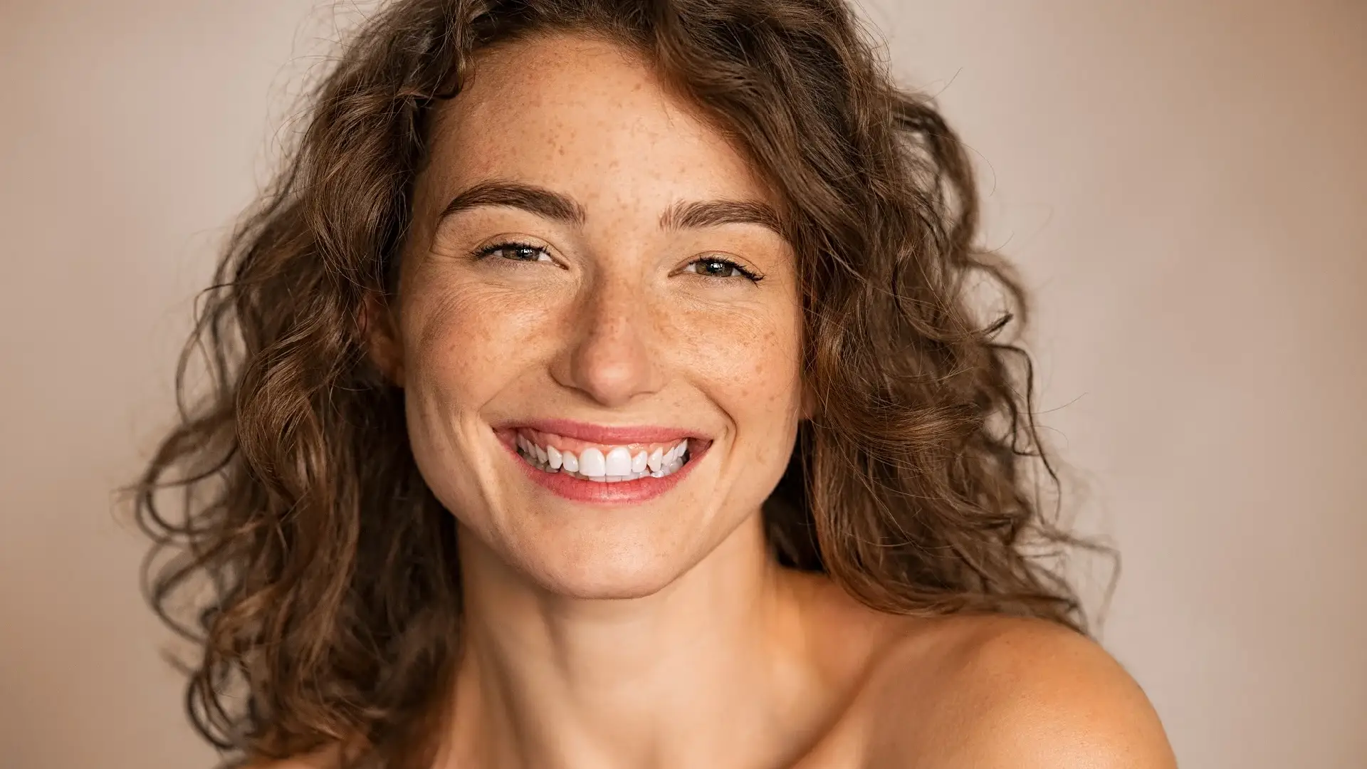 Smiling woman with healthy, glowing skin, reflecting Skin Rejuvenation and Anti-Aging.
