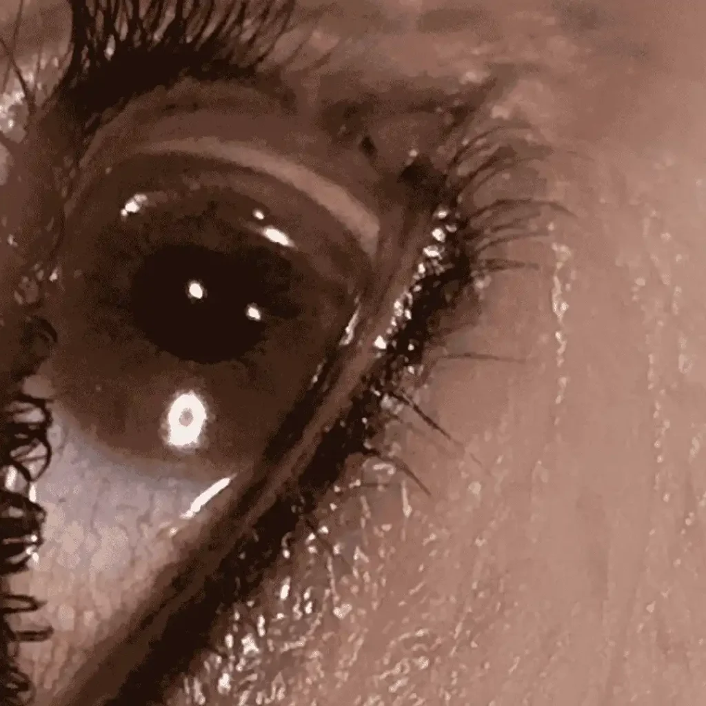 Close-up of an eye showcasing eyeliner treatments, with defined lashes.