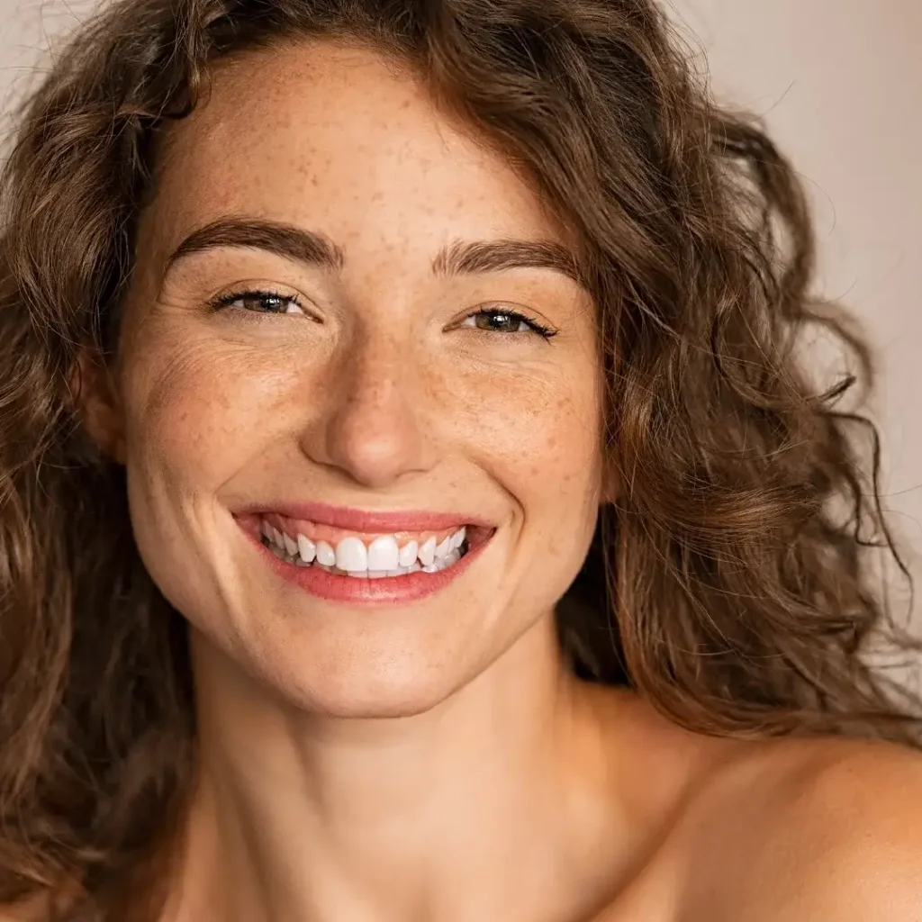 Smiling woman with healthy, glowing skin, reflecting Skin Rejuvenation and Anti-Aging.